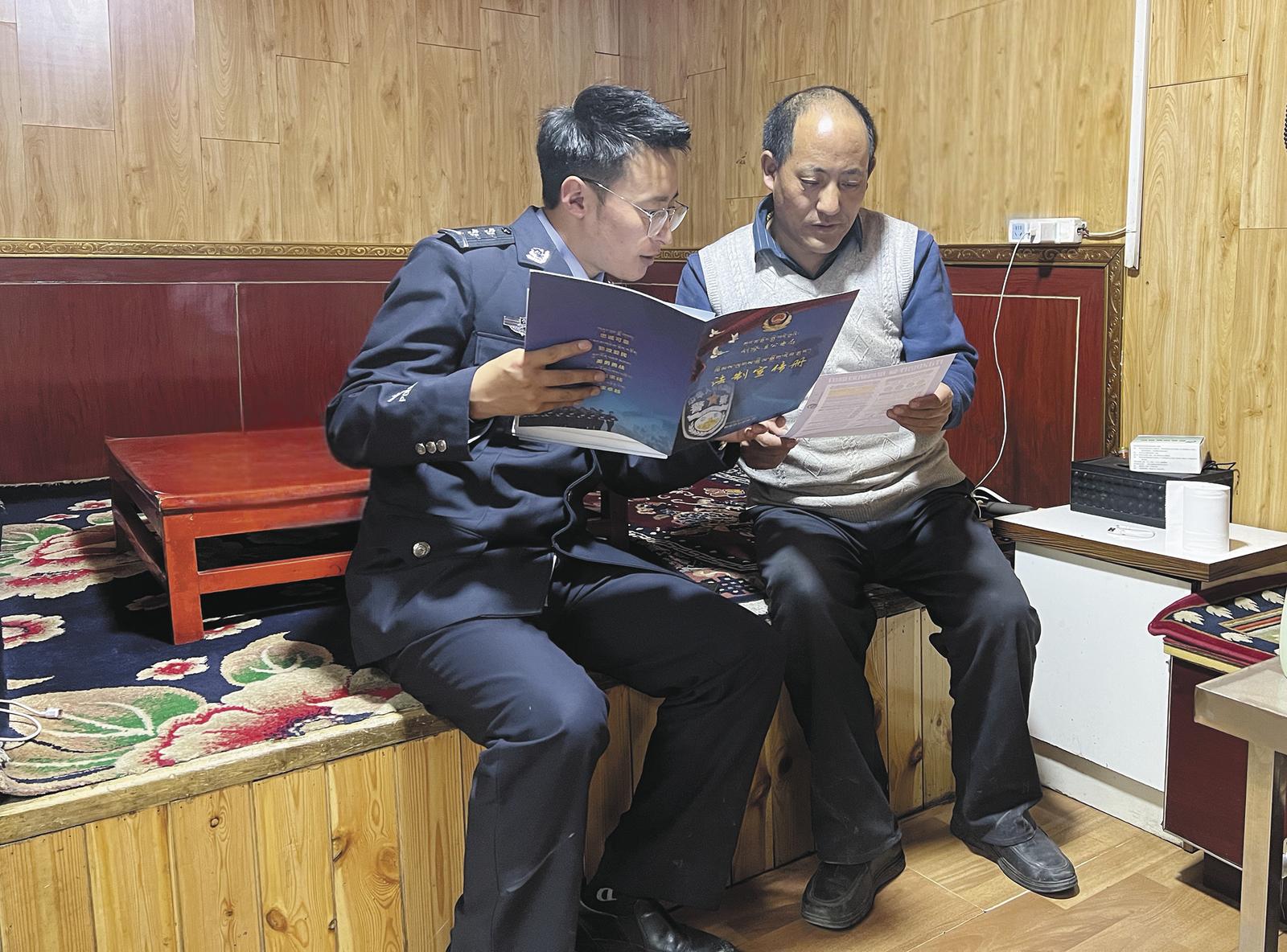 尕布藏尼玛(左)向群众宣传法律知识。受访者供图